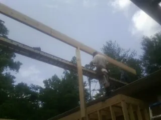Carpenter setting a ridge beam over a new addition frame — Ice Dam Removal by Roofing Brothers in Pine Beach