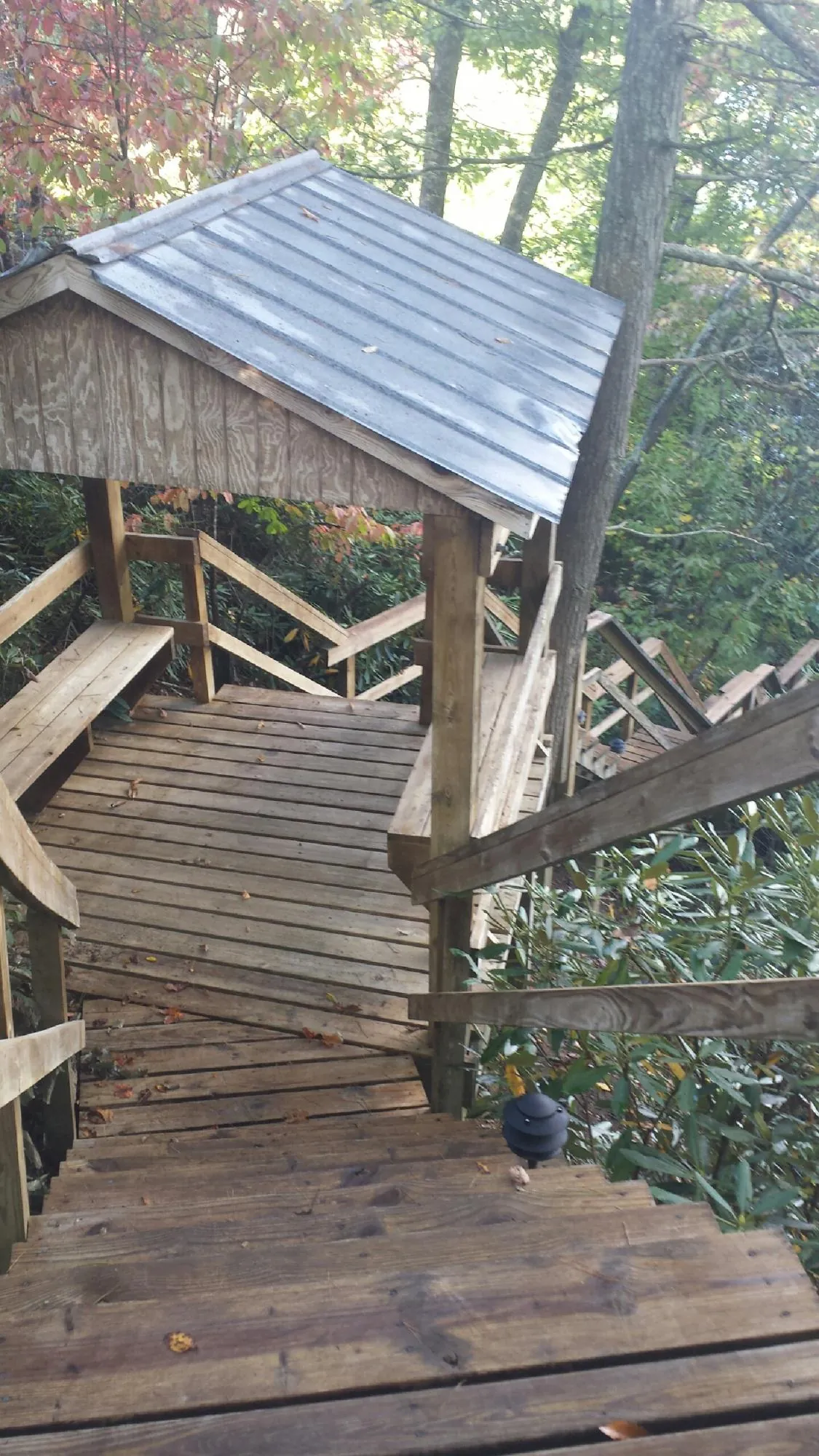Metal roofed shelter over wooden steps on a wooded walkway — Skylight Repair & Installation work by our crew in Pine Beach