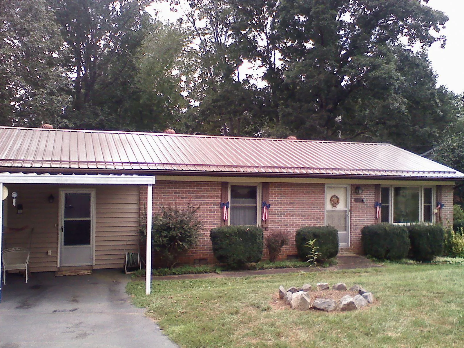 Bronze metal roof and carport on a brick ranch home — Roof Repair work by our crew in Pine Beach